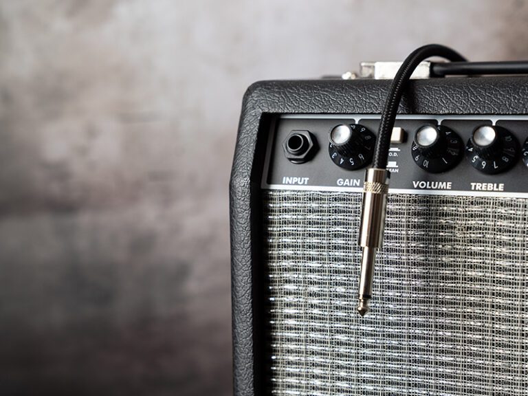 Guitar amp with cord hanging over the top of it