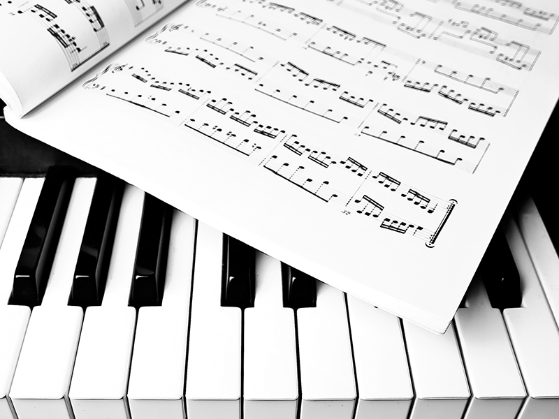 Music book sitting on top of piano keys